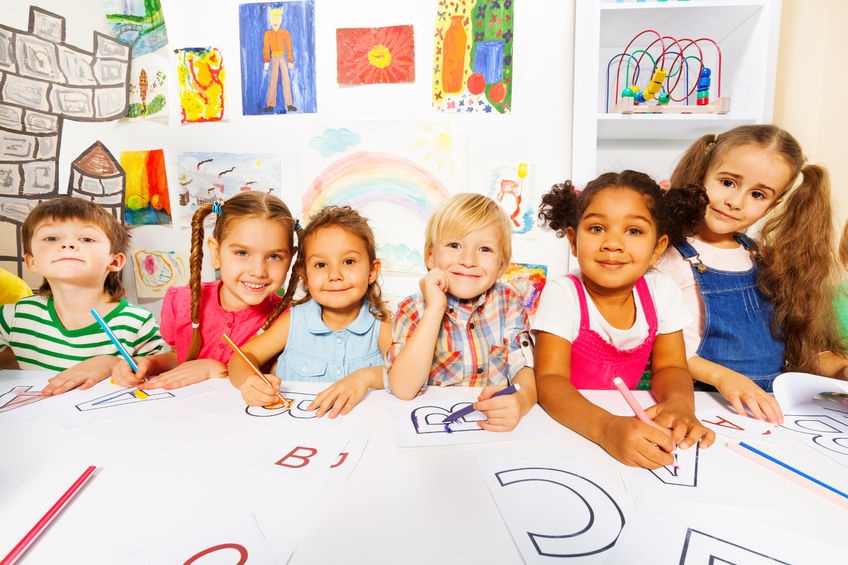 boys and girls drawing letters at a table 